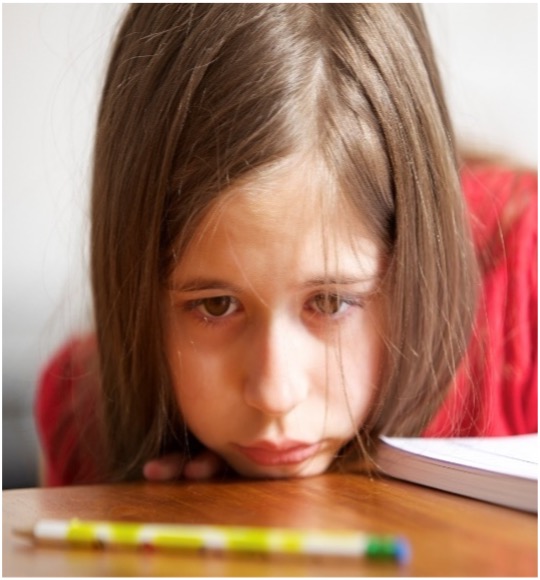 Sad Girl with face on schooltable
